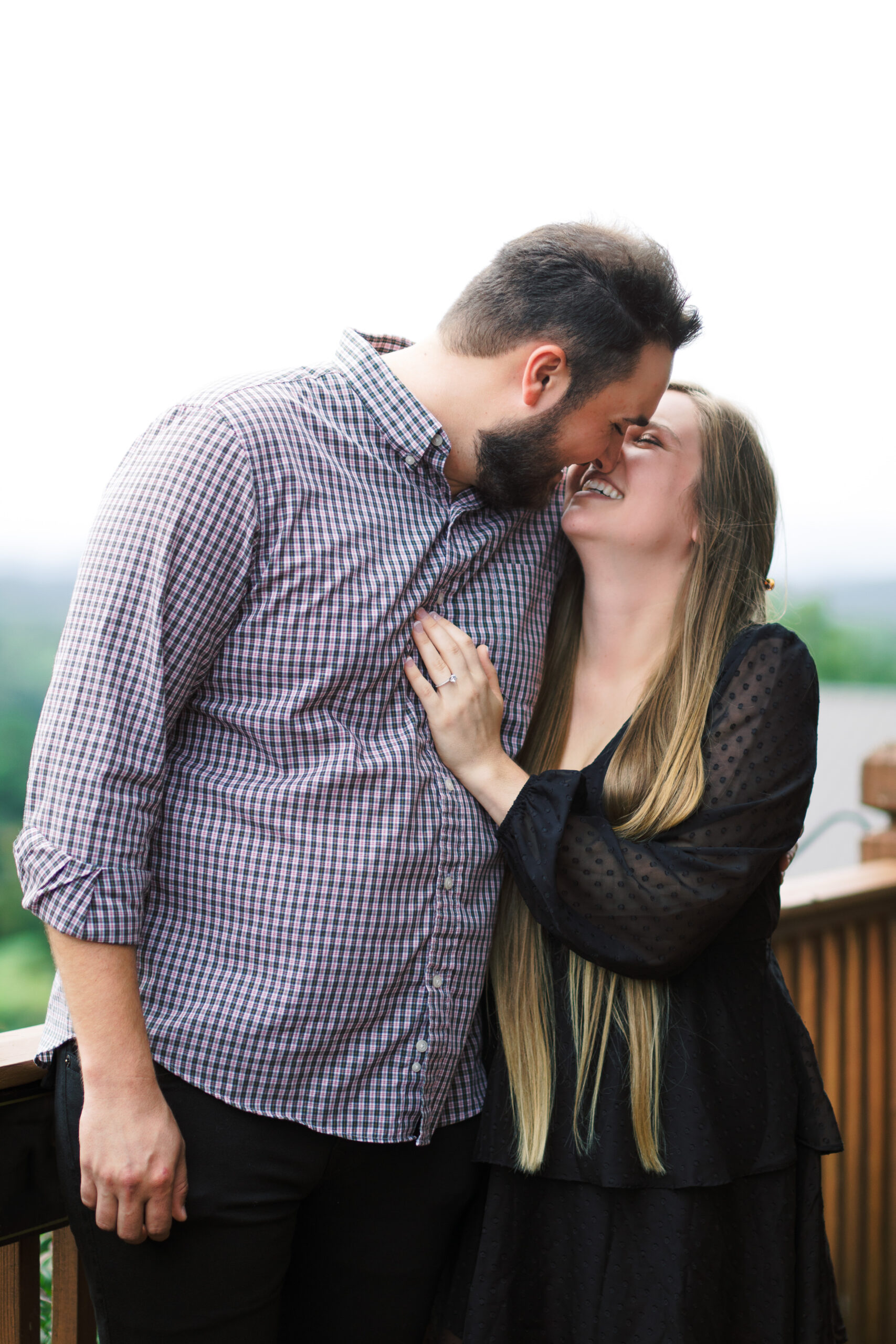 Couple sweetly kisses after becoming engaged at Wolf Mountain Vineyards in Dahlonega, Georgia