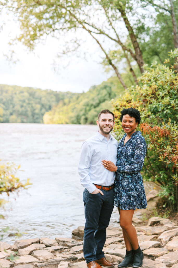 Couple poses together on Chattahoochee river for a Chattahoochee Coffee Company engagement photography session