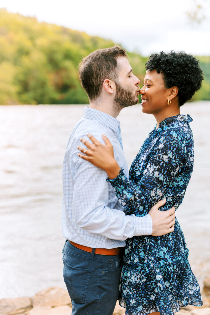 Man gently kisses fiance's nose during engagement photo session at Chattahoochee Coffe Company in Atlanta, Georgia