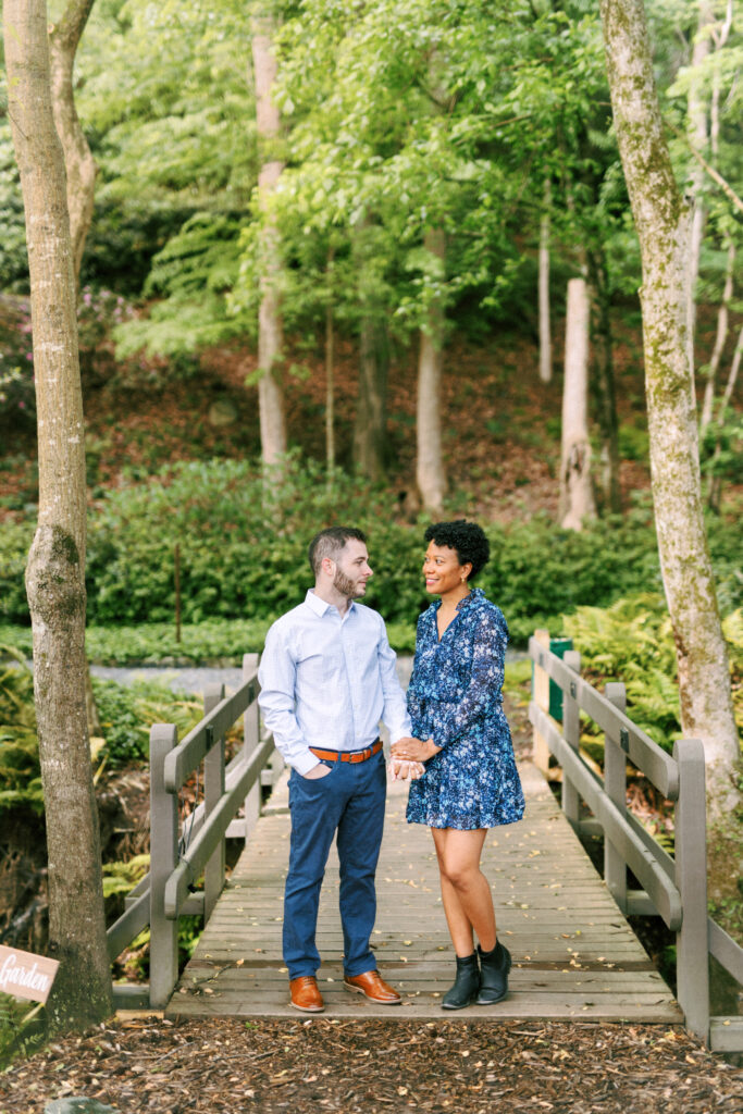 Couple holds hands on a bridge at the Chattahoochee Coffee Company for a engagement photography session