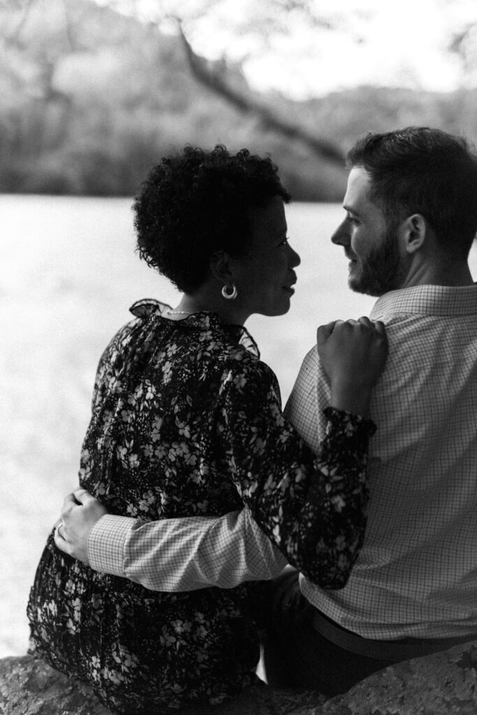 Couple intimately sits on Chattahoochee river for a Chattahoochee Coffee Company engagement photography session