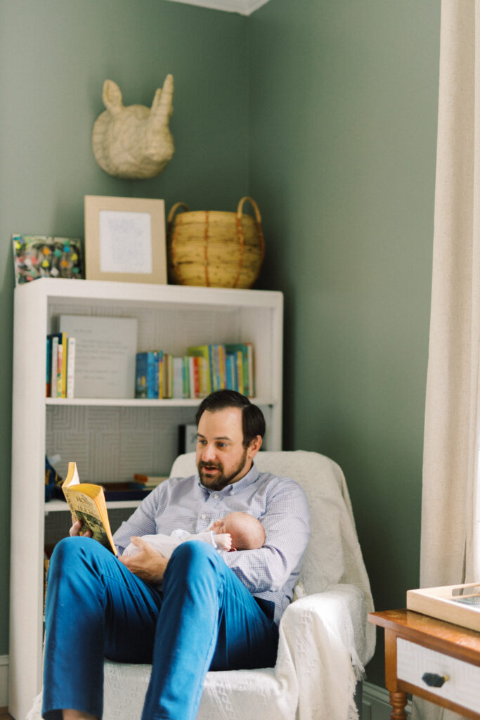 Dad reading The Hobbit to newborn baby