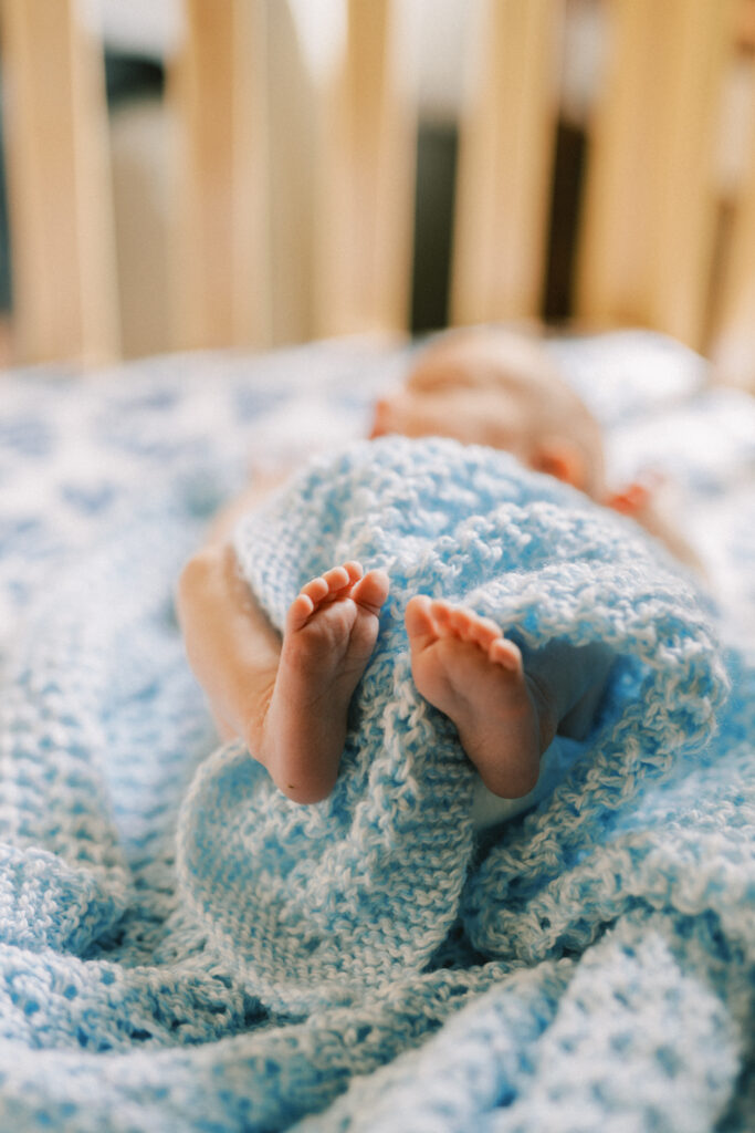 Newborn baby swaddled with tiny feet