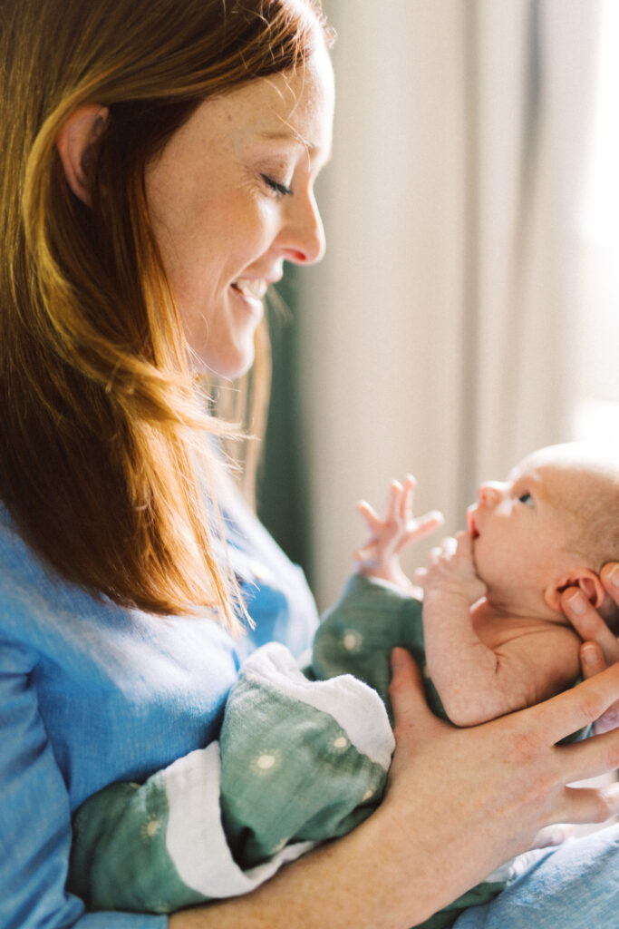 Mother smiling upon newborn baby in Marietta, Georgia nursery