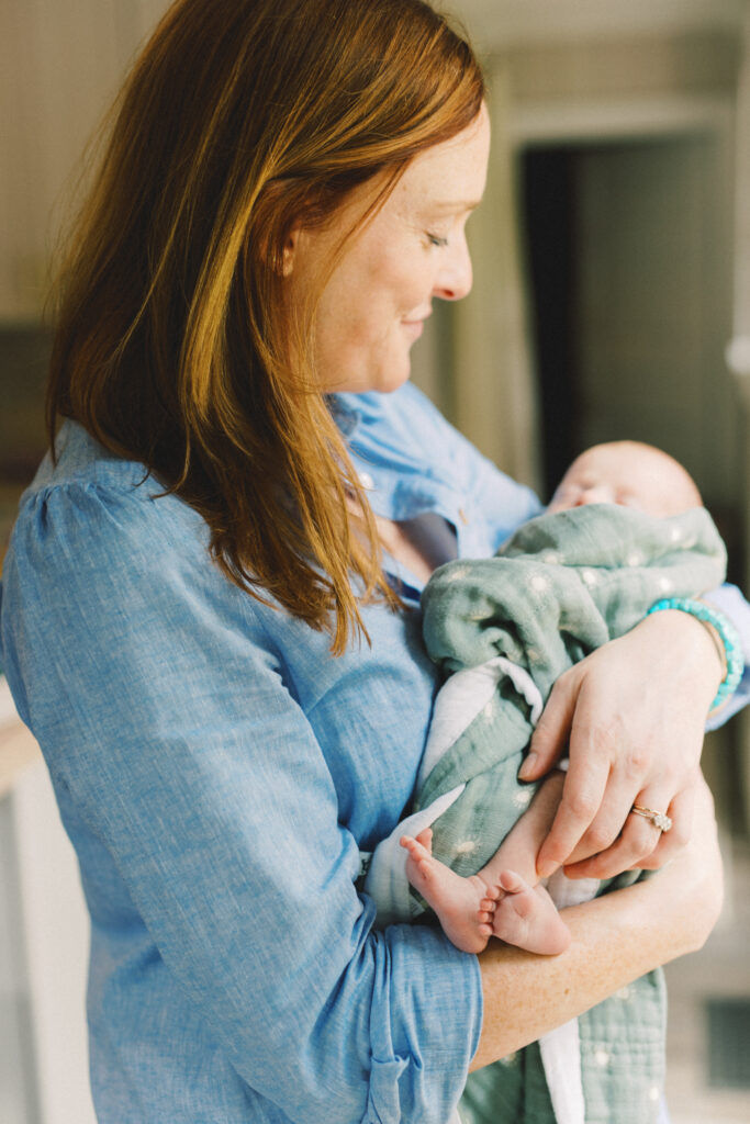 Newborn mom admires tiny baby