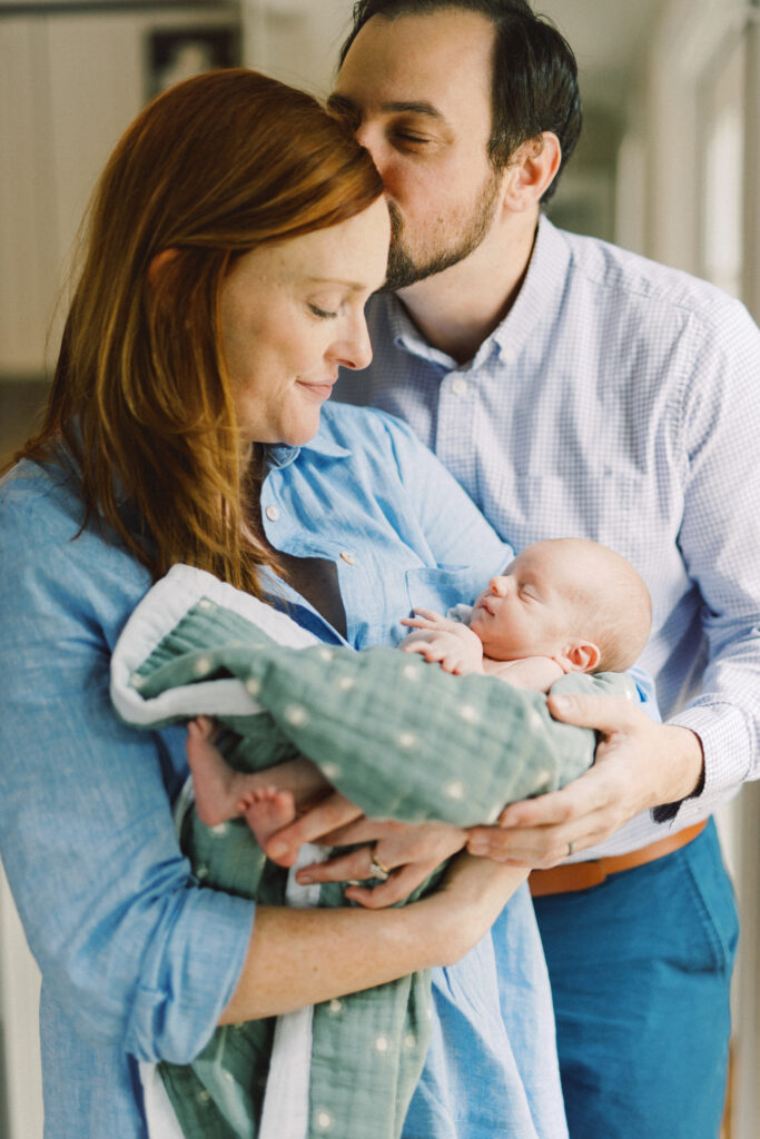 Newborn parents holding baby