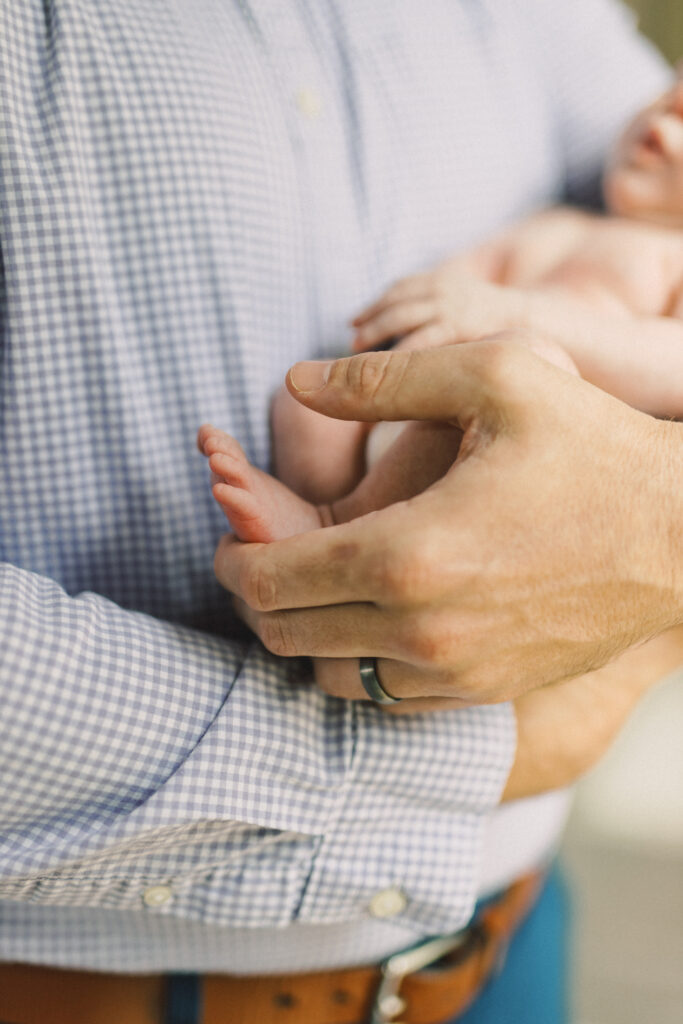 Father holding tiny newborn feet