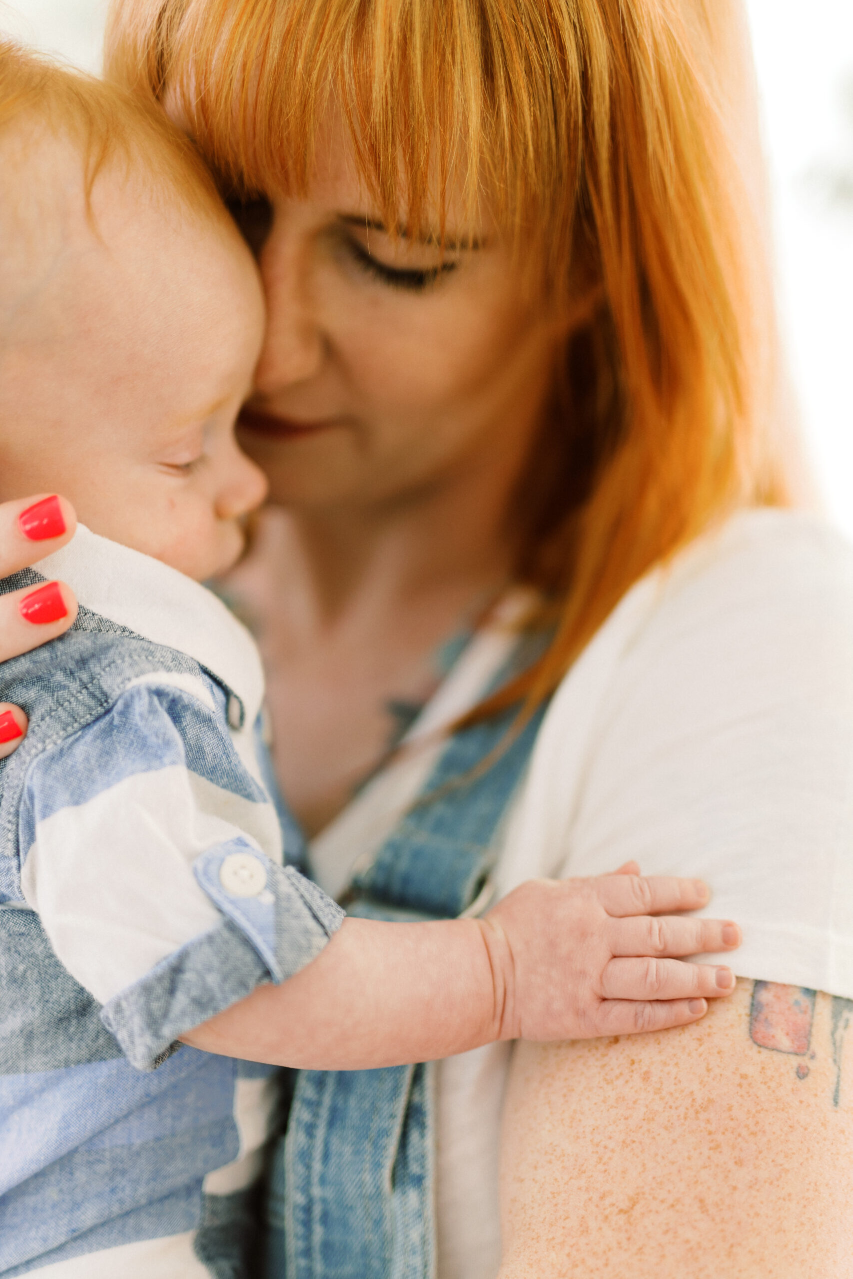 Baby and mom put foreheads together during motherhood & milestones session at Kiah Studios in Woodstock, Georgia