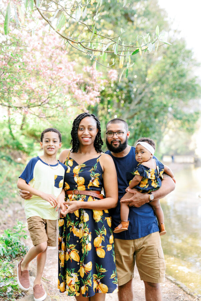 Family of four smiles for photo while wearing matching lemon outfits in Piedmont Park, Atlanta