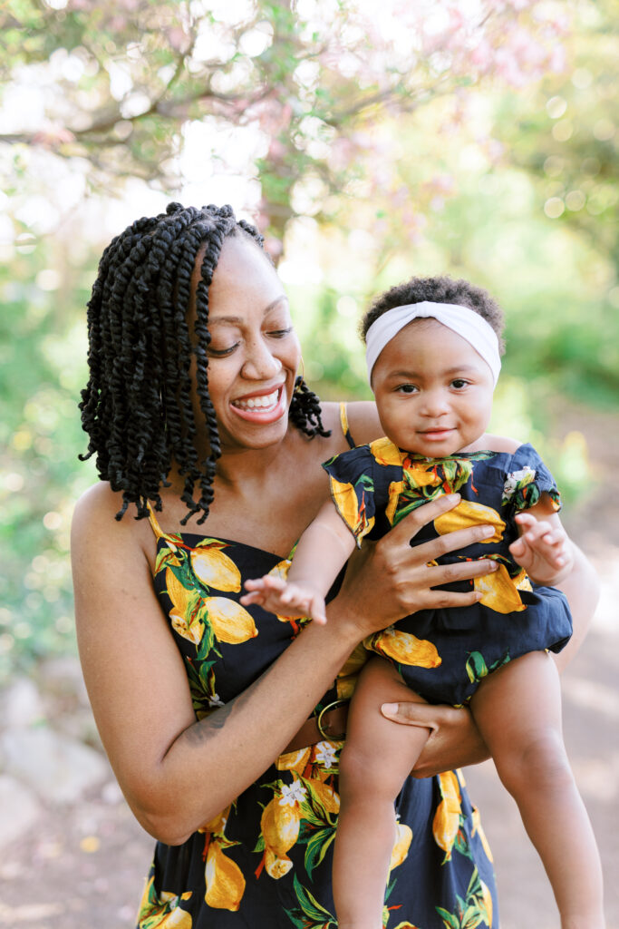 Mom and daughter laugh while wearing matching dresses in Piedmont Park, Atlanta