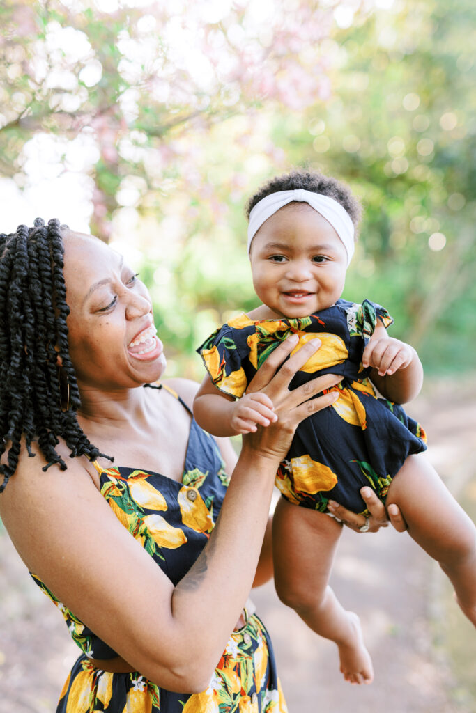 Mom and daughter laugh while wearing matching dresses in Piedmont Park, Atlanta