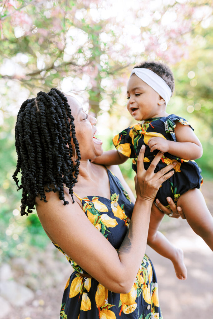 Mom and daughter laugh while wearing matching dresses in Piedmont Park, Atlanta