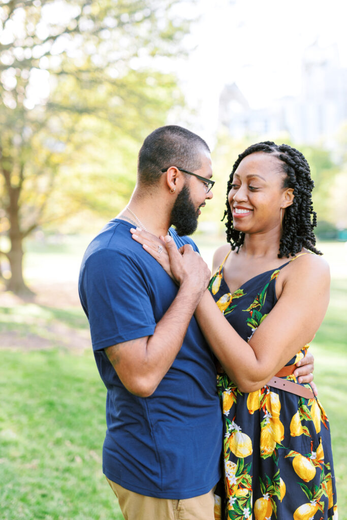 Couple smiles at each other in front of beautiful Atlanta, Georgia Skyline at sunset