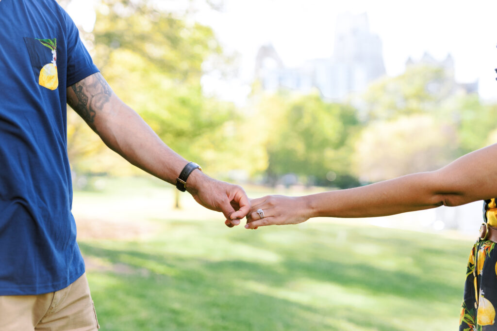 Couple holds hands in front of beautiful Atlanta, Georgia Skyline at sunset