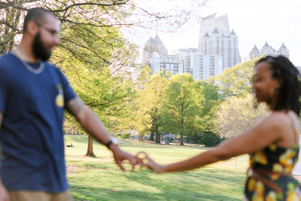 Couple holds hands in front of beautiful Atlanta, Georgia Skyline at sunset