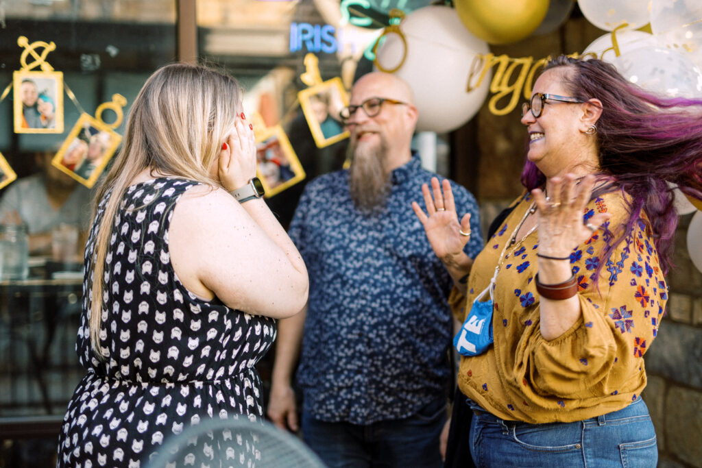 Newly engaged woman celebrates in surprise after proposal at Keegan's Public House in Kennesaw, Georgia