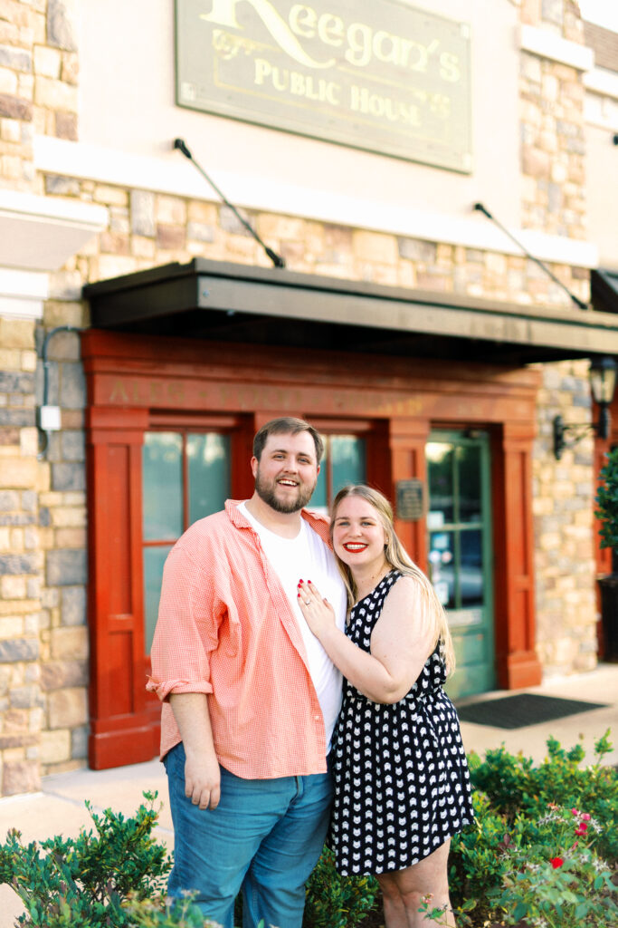 Newly engaged couple smiles together after proposal at surprise engagement party Keegan's Public House in Kennesaw, Georgia