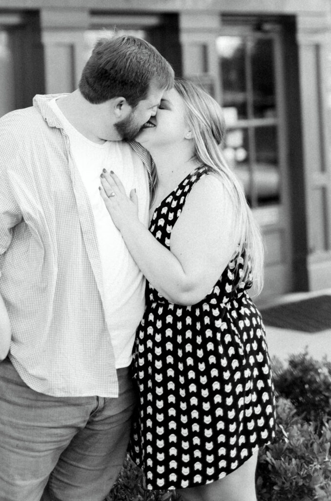 Newly engaged couple kisses after proposal at surprise engagement party Keegan's Public House in Kennesaw, Georgia