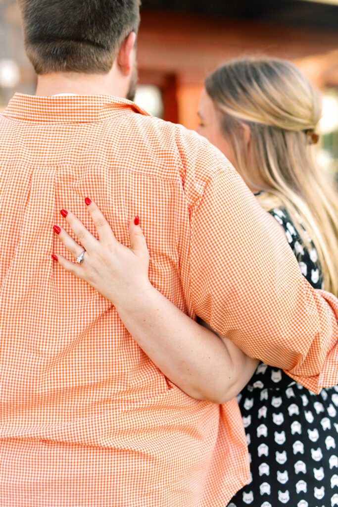 Newly engaged couple hugs after proposal at surprise engagement party Keegan's Public House in Kennesaw, Georgia