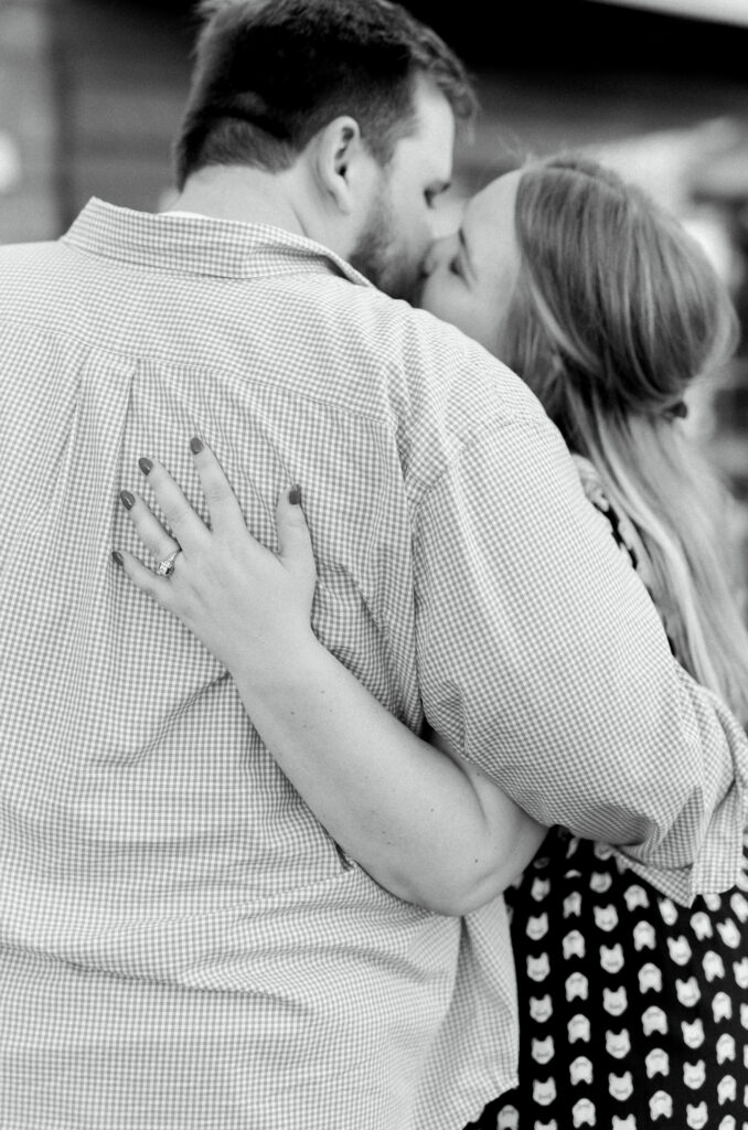 Newly engaged couple kisses after proposal at surprise engagement party Keegan's Public House in Kennesaw, Georgia