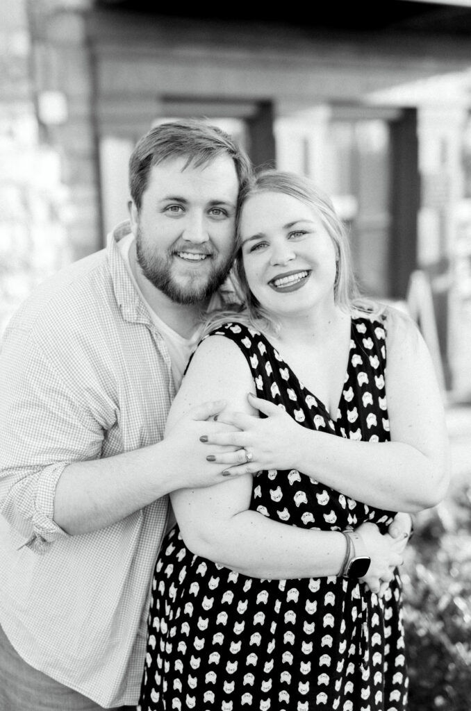 Newly engaged couple smiles together after proposal at surprise engagement party Keegan's Public House in Kennesaw, Georgia