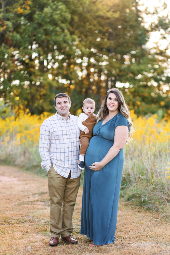 Family poses during maternity photoshoot at Green Meadows Preserve