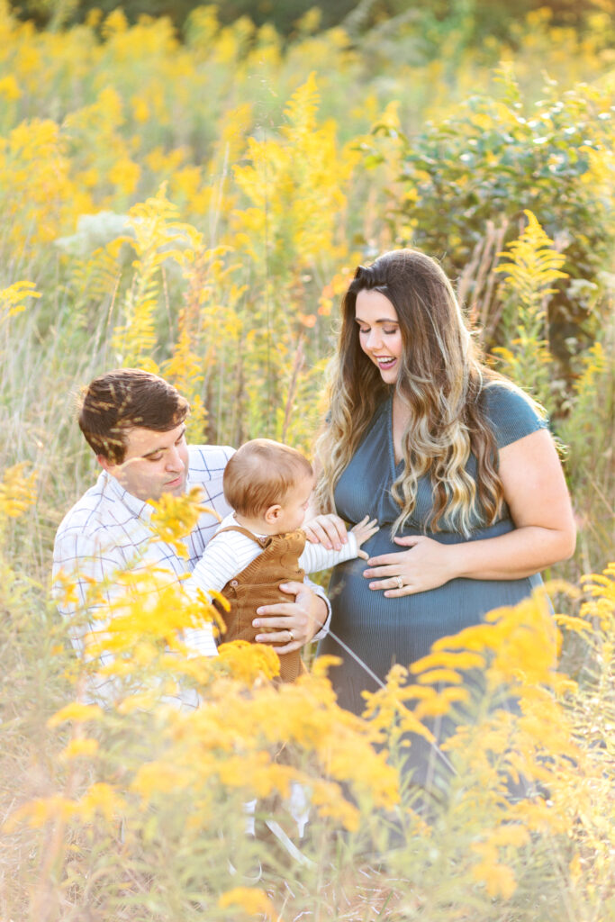 Toddler touches mom's baby bump during maternity photoshoot at Green Meadows Preserve