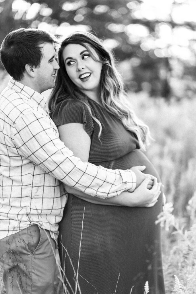 Pregnant mom looks back at dad during maternity photoshoot at Green Meadows Preserve in Marietta, Georgia