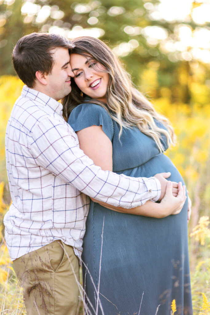 Pregnant mom looks back at dad during maternity photoshoot at Green Meadows Preserve in Marietta, Georgia