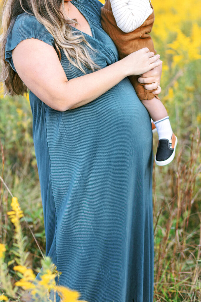 Pregnant mom shares moment with toddler during motherhood photoshoot at Green Meadows Preserve in Marietta, Georgia