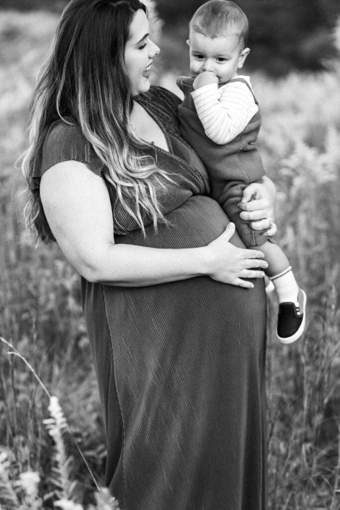 Pregnant mom shares moment with toddler during motherhood photoshoot at Green Meadows Preserve in Marietta, Georgia