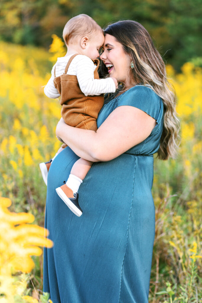 Pregnant mom holds toddler during motherhood photoshoot at Green Meadows Preserve in Marietta, Georgia