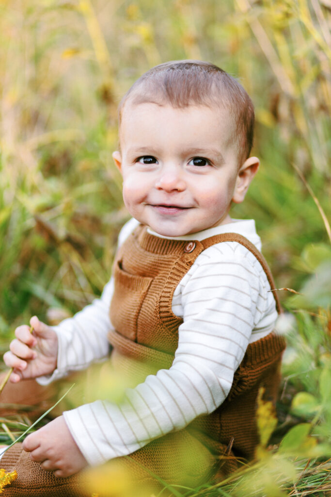 Toddler smiles in a field during motherhood photoshoot at Green Meadows Preserve in Marietta, Georgia