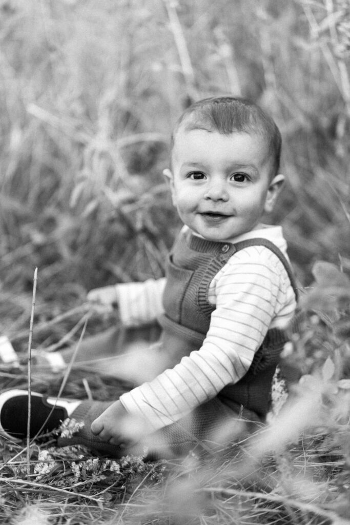 Toddler smiles in a field during motherhood photoshoot at Green Meadows Preserve in Marietta, Georgia