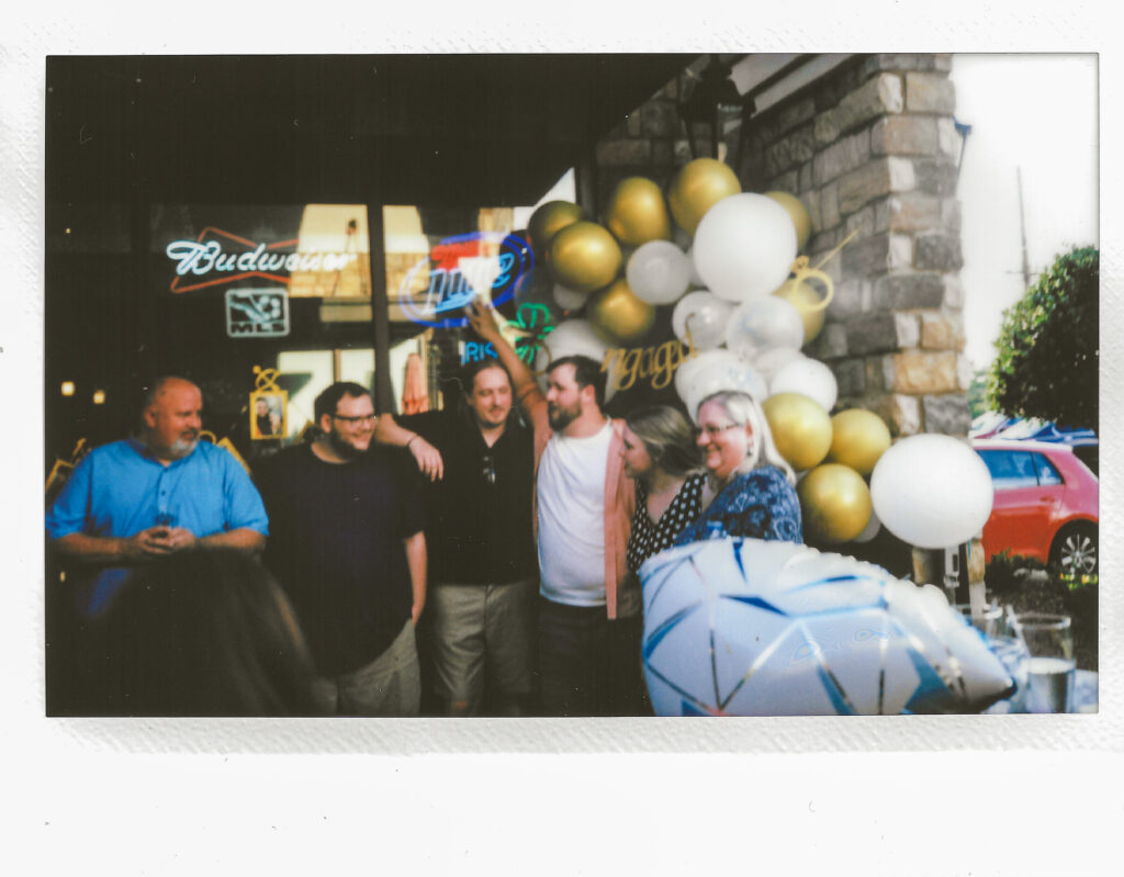 Instant photo, polaroid of couple's family at surprise engagement party at Keegan's Irish Pub in Kennesaw, Georgia