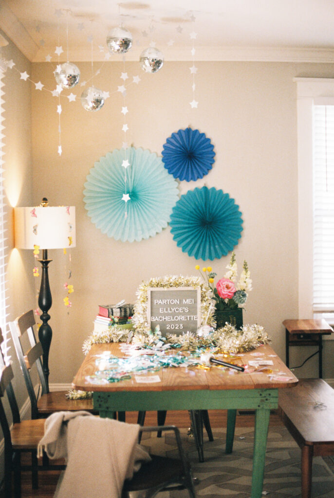 Table decorations for a Dolly Parton themed bachelorette party in Chattanooga, Tennessee. Disco balls, butterflies, books, colorful flowers, and a microphone are on display