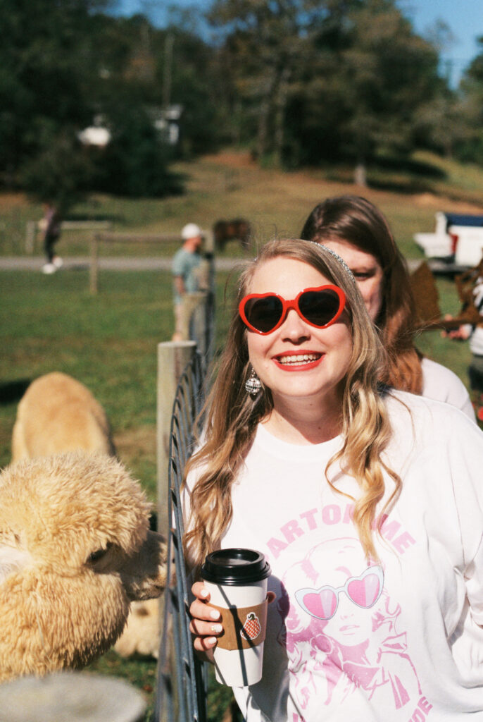 Parton me, I'm the bride! Bride smiles with an alpaca on a Dolly Parton themed bachelorette party in Chattanooga, Tennessee