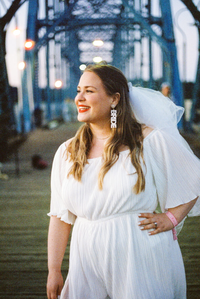 Bride poses for photo on Walnut street bridge in Chattanooga, TN, wearing veil and bride earrings